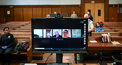 Photo of a computer Monitor showing participants in a virtual court trial