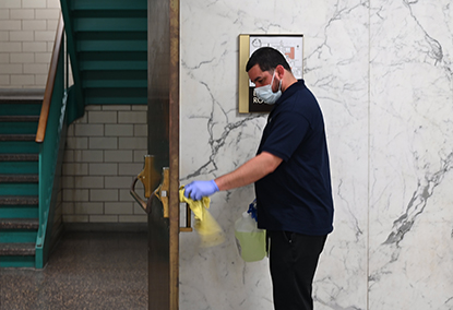 Photo of Court Staff cleaning door handle