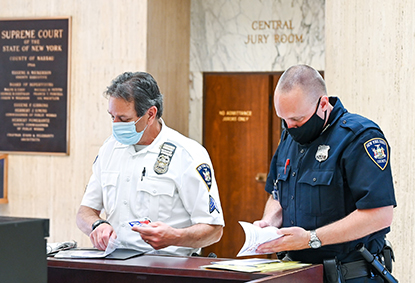 Court Sgt. Bill Hess, left and Officer Michael Leader wearing protective equipment at the entrance to the Nassau County Court in Mineola, NY on Friday, May 29, 2020