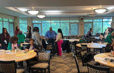 People discuss topics in small groups in a meeting room