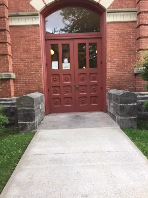 Description of photo: A walkway that leads to an entrance of double doors.