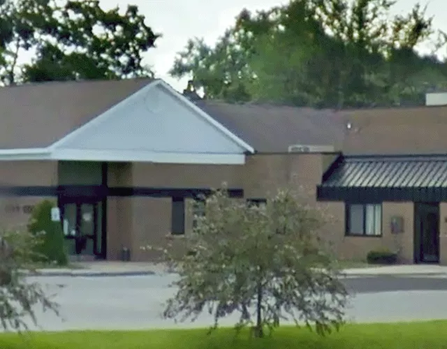 A view of the courthouse from the parking area. The entrance to the courthouse is accessed from the sidewalk and the parking area.