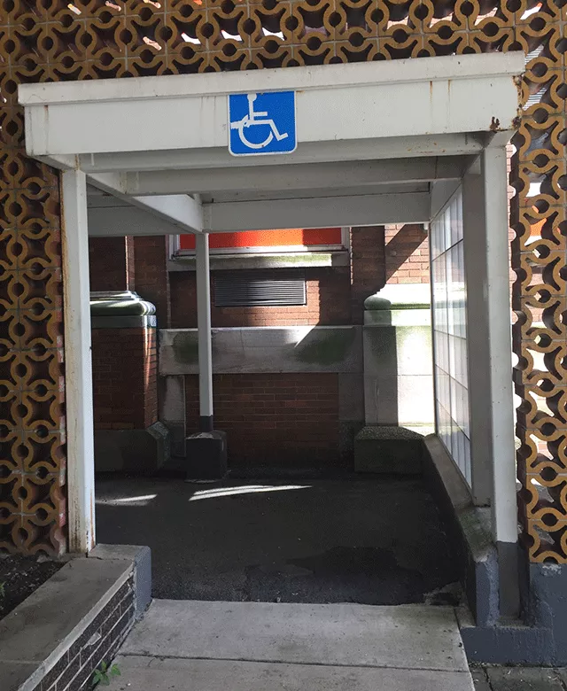Description of photo: A walk way with ADA signage that leads to the building.