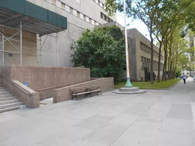 Description of photo: A view of the courthouse from the sidewalk. There are steps to the left and directly to the right is the entrance the ramp. The courthouse extends to the end of the block.