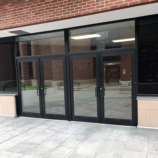 Description of photo: Two double doors entry to the court facility. The door is accessed directly from the sidewalk.