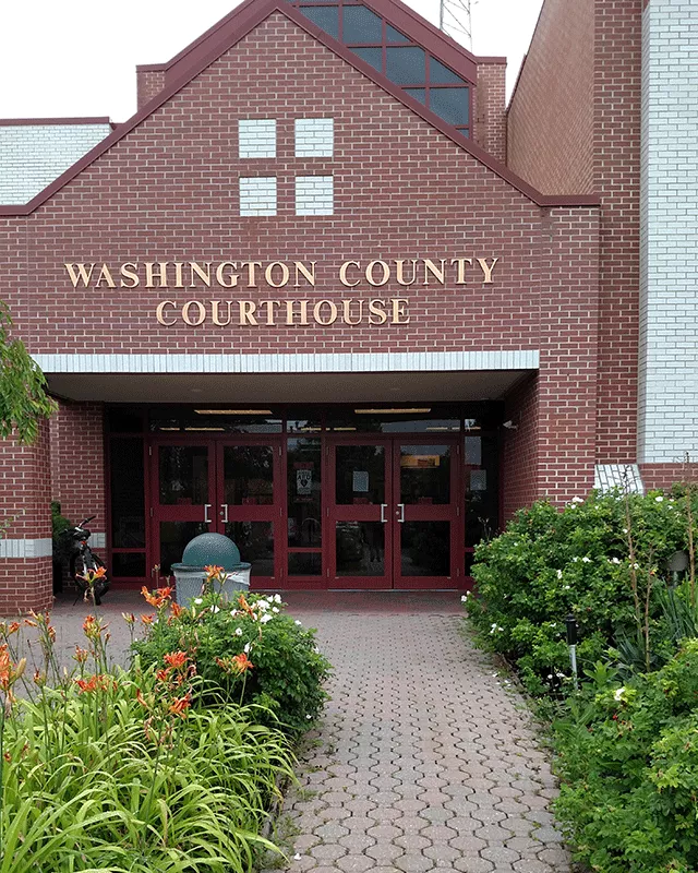 Description of photo: A walkway leading to the Washington County Courthouse. The entrance to the courthouse has two double doors.
