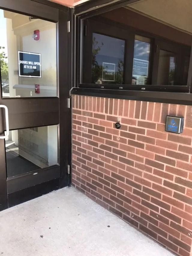 Courthouse with a single door entrance. There is a push button on the right side of the building.
