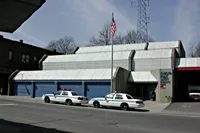 Description of photo: Courthouse with two police cars in front of it.