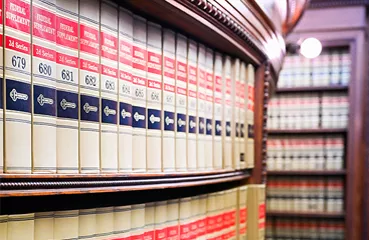 a law library bookshelf filled with legal reference volumes, specifically "Federal Supplement" reporters. 