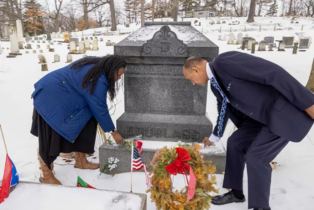 Judges Richardson and St. George place flowers at Frederick Douglass's gravesite at the Mt. Hope Cemetery in Rochester