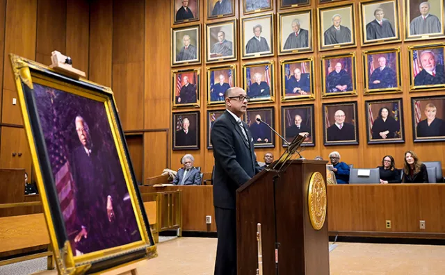 First Deputy Chief Administrative Judge Norman St. George speaks to a crowded ceremonial courtroom 