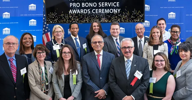Photo of a group of attorneys standing underneath a banner than reads Pro Bono Service Awards Ceremony.