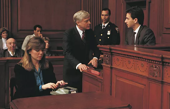 Courtroom with court reporter typing while attorney is quesitoning a witness.