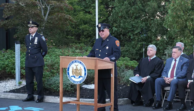 Photo: Pictured at the podium is keynote speaker Detective Edwin Hugh, who shared his riveting story as a 9/11 first responder, assigned to the NYPD’s elite Manhattan North Task Force. Seated (right) are Suffolk County Administrative Judge Andrew Crecca and Suffolk County Executive Edward Romaine. Suffolk County Chief of Court Security David Santiago stands to Detective Hugh’s left. 