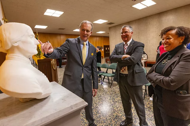 Seventh Judicial District Administrative Judge William K. Taylor points out a detail of the Susan B. Anthony statue to Deputy Chief Administrative Judge for Courts Outside New York City James P. Murphy and UCS Statewide Civic Engagement Coordinator Zenith T. Taylor at the Rochester dedication ceremony 