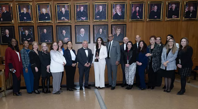 A group of program presenters and attendees gather for a photo