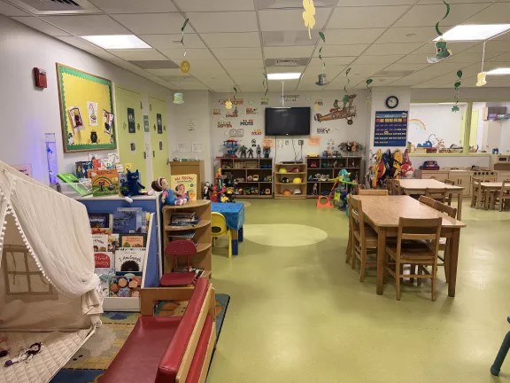 A photo of part of the Bronx Family Court Children's Center with desks, chairs, toys, and books visible