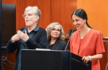 An ASL translator translating on a podium in courthouse