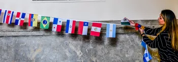 Woman holds flags from many nations.