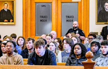 Photo of a large group of teenagers sitting in a courtroom.