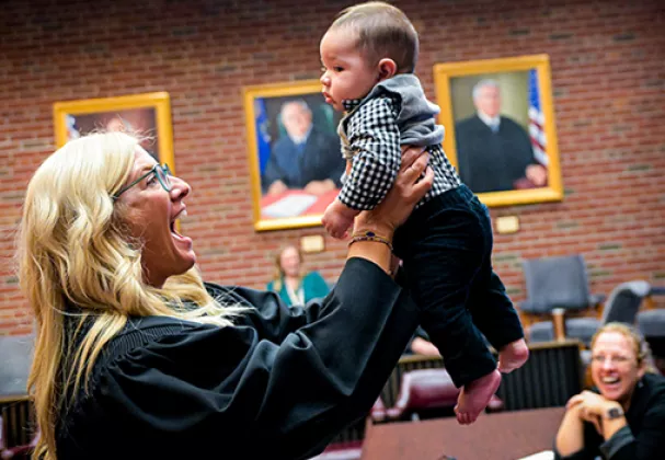 Photo of a Family Court Judge holding up an infant