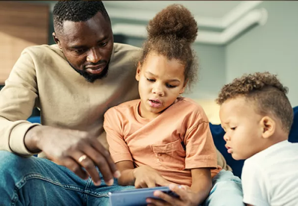 Photo of adult man with two young children