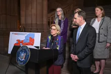 Assembly Member Andrew Hevesi, member of the Permanent Commission on Justice for Families, looks on as Senator Shelley Mayer delivers remarks in the NYS Capitol building.