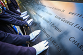 Photo of Court Officers touching the names of the 9-11 memorial